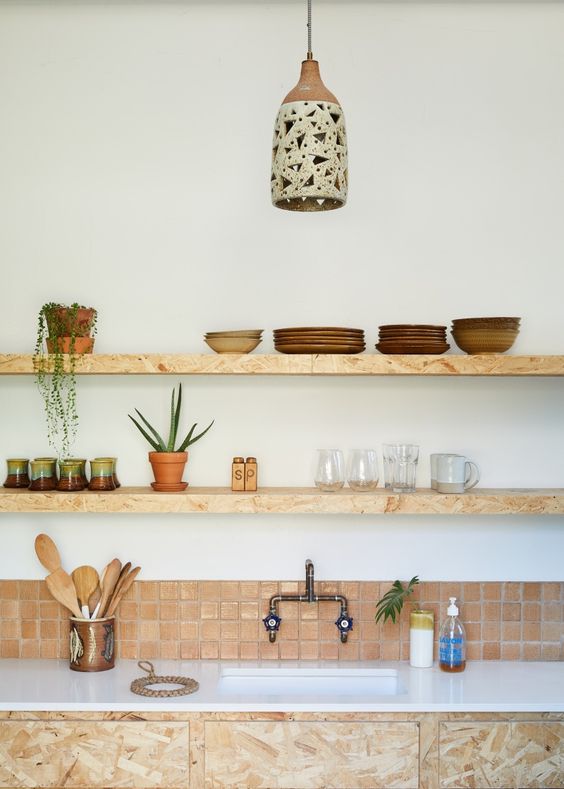 a creative kitchen with a small terracotta tile backsplash, open shelves instead of cabinets and a pendant lamp