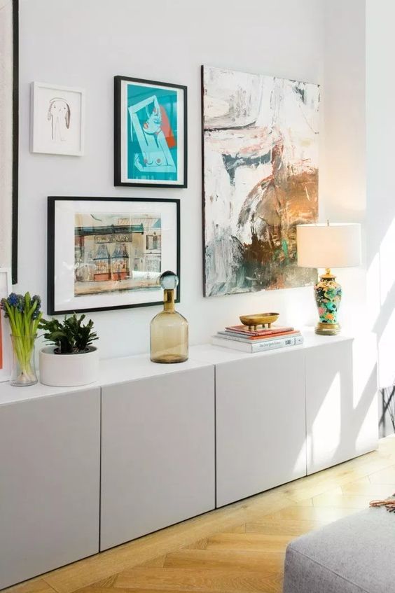 a dove grey IKEA Metod credenza with decor, potted plants, lamps and a bold gallery wall