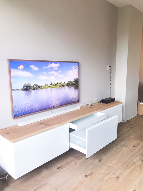 a floating white TV unit of IKEA Metod, with a butcherblock countertop for a Scandinavian space
