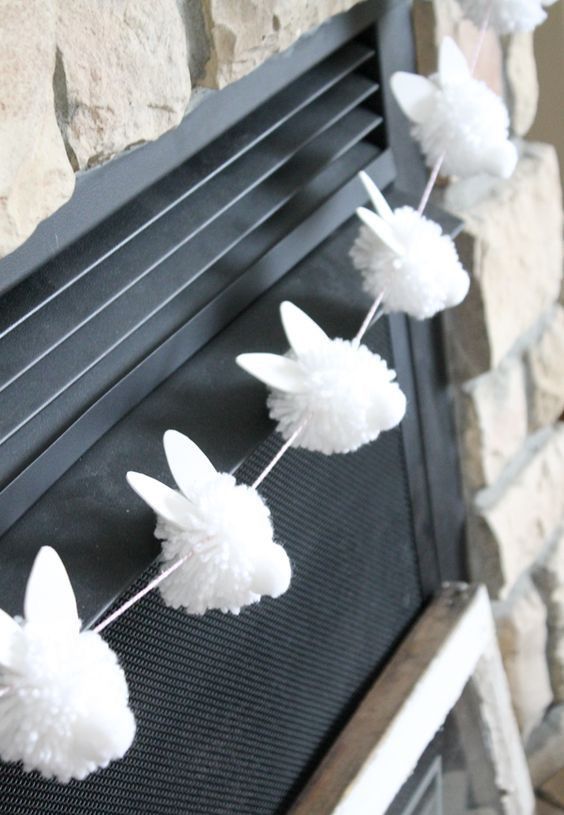 a funny bunny garland of white pompoms, ears and tails is a cool idea for spring andEaster, it can be easily DIYed