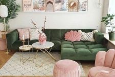 a lovely living room with a green sectional, a pink chair and a pouf, some pillows, a ledge gallery wall and potted plants