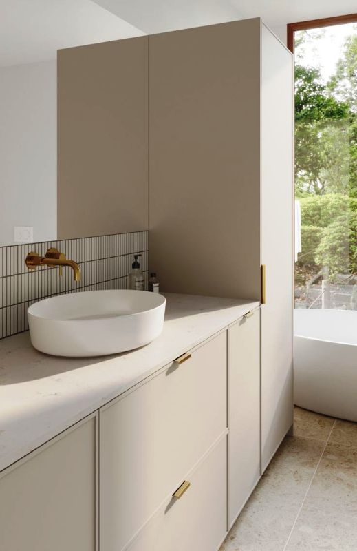 a minimalist bathroom with greige storage units including IKEA Metod, a bathtub and a skinny tile backsplash
