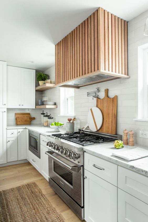 a modern farmhouse kitchen with stone countertops, a white tile backsplash, a fluted hood and open shelves