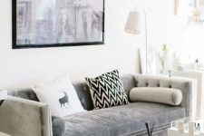 a modern living room is added a textural touch with an acrylic table and a grey velvet sofa