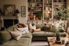 a natural palette living room with greige walls, a green sectional, earthy pillows, lots of greenery is welcoming