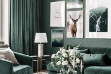 a nature-inspired living room with grey green walls, hunter green furniture and matching curtains and a large gallery wall