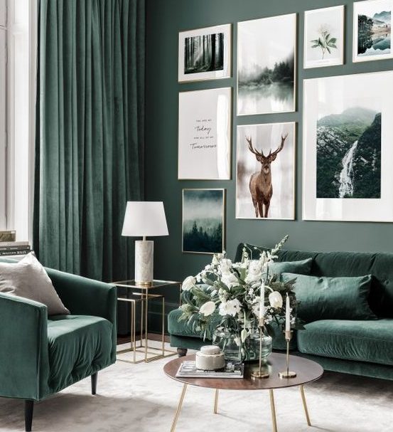 A nature inspired living room with grey green walls, hunter green furniture and matching curtains and a large gallery wall