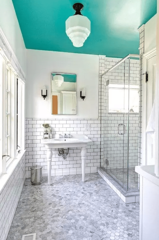 a neutral bathroom spruced up with a bold aqua-colored ceiling that brings color and makes the space non-boring