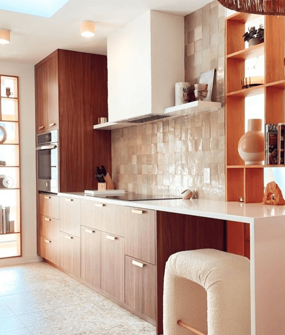 A rich stained kitchen with a tan tile backsplash, white countertops, a white hood and a lovely bent stool