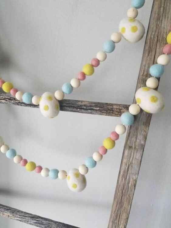 a simple pastel pompom and egg garland is a cool and cute decoration for spring and Easter