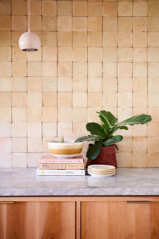 a stained kitchen with stone countertops, terracotta tiles and a blush pendant lamp is amazing