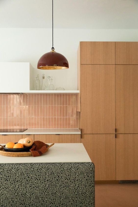 A stained mid century modern kitchen with sleek cabinets, white countertops, a glazed terracotta tile backsplash