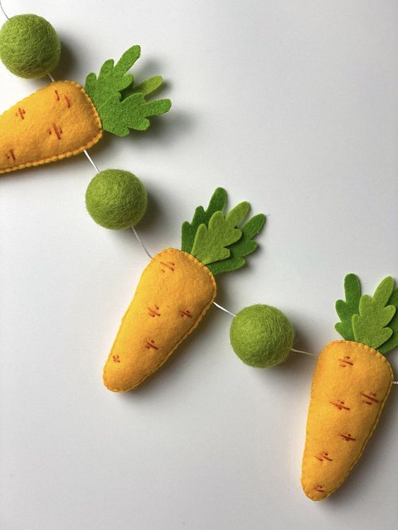 a whimsical spring garland of felt carrots and green balls is a cool idea for spring and Easter