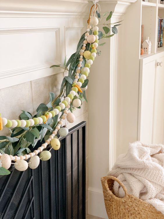 an arrangement of pastel pompom garlands, eggs, greenery and beads is a fun idea for spring