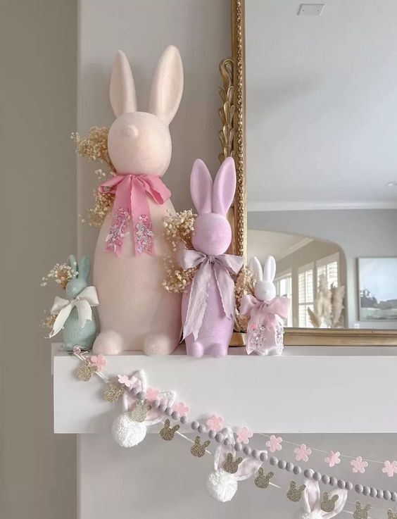 an arrangement of several garlands with bunny heads, beads and pink flowers plus some bunnies on the mantel for spring