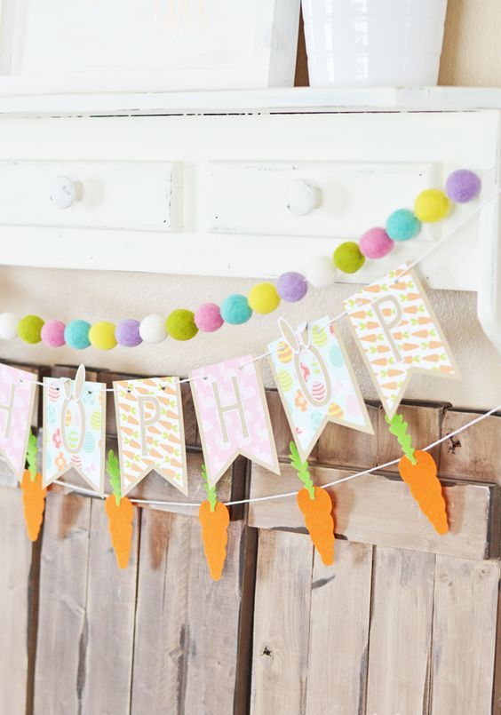 an arrangement of spring garlands, a carrot banner, a letter banner and a colorful pompom garland