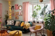 an eclectic living room with mint walls, a dark green sofa, a pink chair, a yellow ottoman, a bright gallery wall and lights