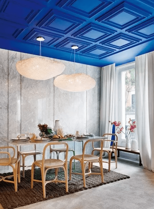 an electric blue paneled ceiling is a major color statement and design feature of the dining room
