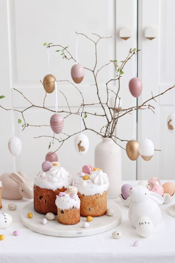 branches in a white vase decorated with pink, white and gold fake eggs is a cool Easter tree to rock
