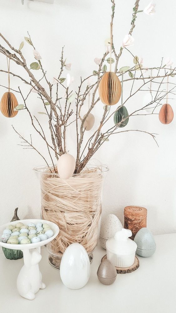 branches with faux leaves and blooms and paper pastel eggs are a cool centerpiece for Easter or for spring, and you can easily DIY it