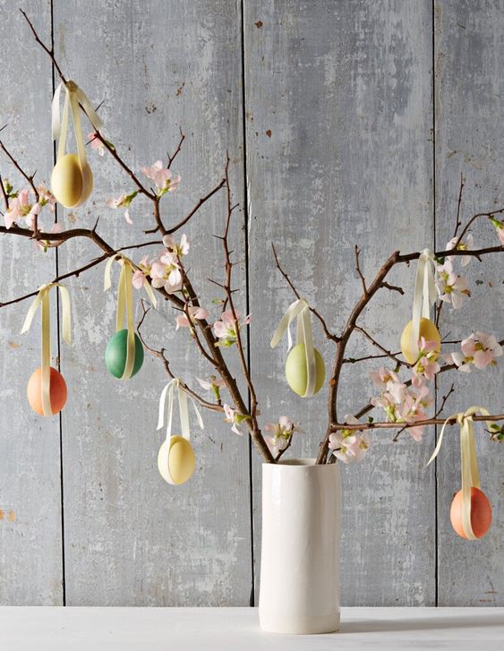 cherry blossom branches decorated with pastel fake eggs and ribbons are a cool Easter tree and you can easily make it