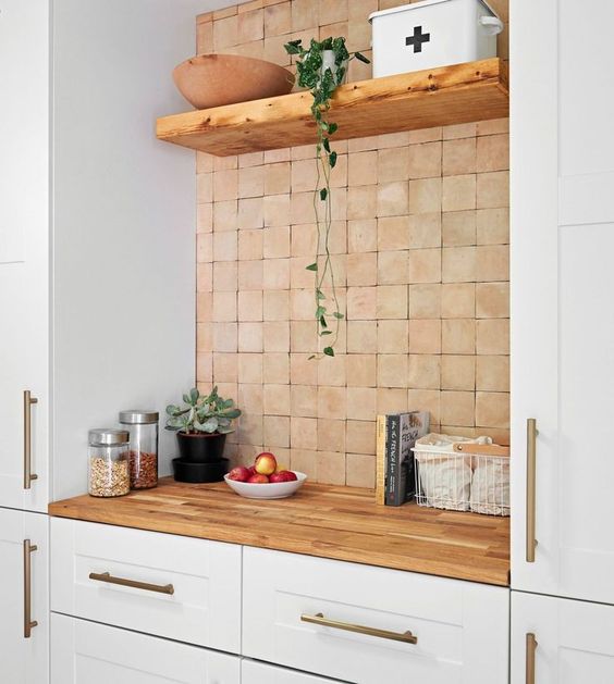 white cabinets, butcherblock countertops and a terracotta tile backsplash make up a cozy and warm combo for a kitchen