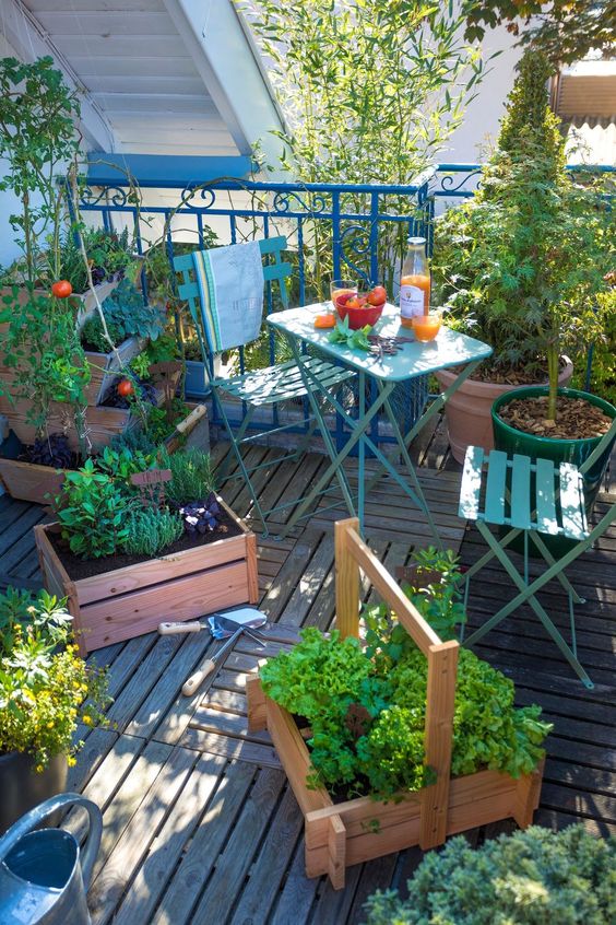 a balcony with folding furniture, boxes with veggies and herbs is a lovely and cozy spot for gardening and not only