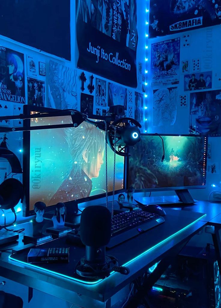 a blue gaming desk setup with bold posters, lights, screens, devices and a small black chair is adorable for playing here