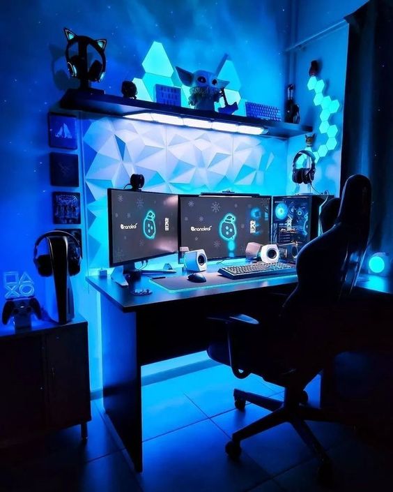a blue gaming nook with a shelf with cool decor, sound-proof panels, blue neon lights, three screens and a PC