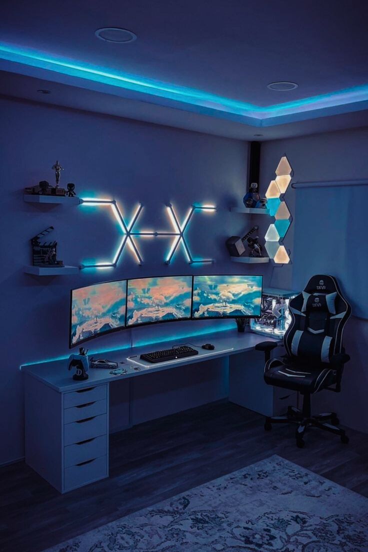 A blue gaming setup with built in and wall lights, a chair, a desk with three screens and shelves with various decor