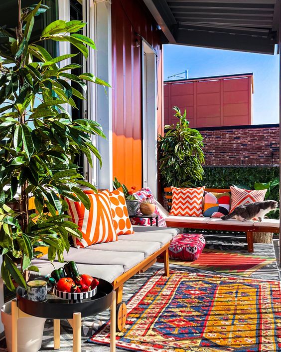 a bold boo terrace with colorful pillows and rugs, a bold wall, potted plants and some decor is amazing