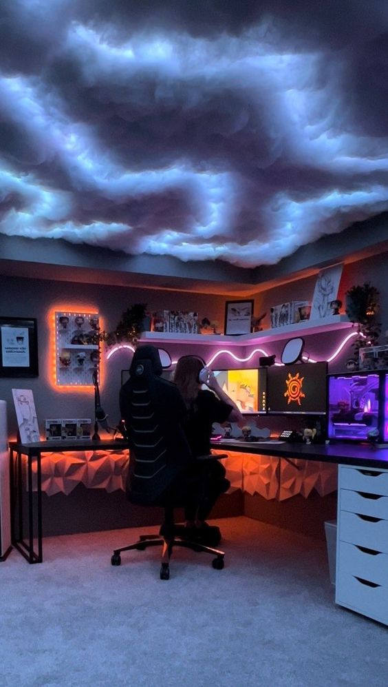 a bold gaming space with cloud lights, a corner desk, some orange and pink lights, a corner shelf and various decor