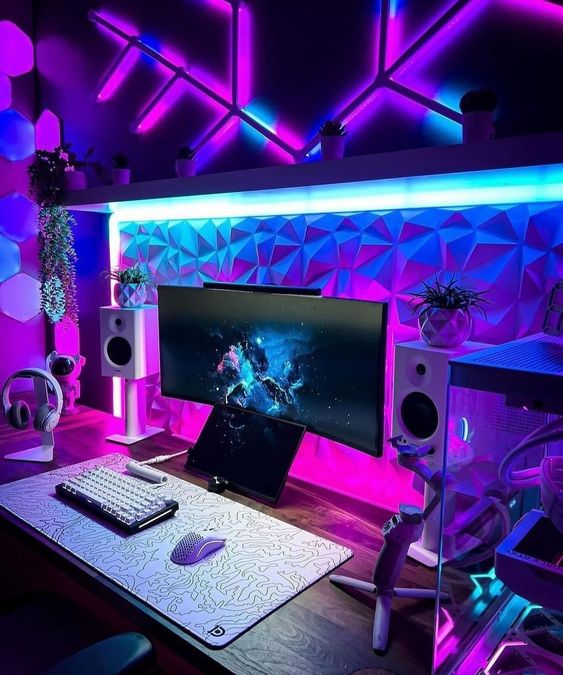 a bold modern gaming desk setup in purple and pink, with a PC, some wall lights, sound-proof panels and ultimate decor