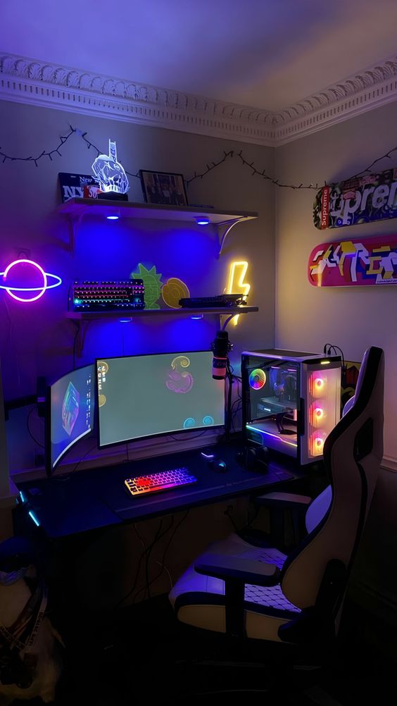 a bold neon gaming desk setup with a PC, soem shelves, bold neon lights and some decor and skateboards is amazing