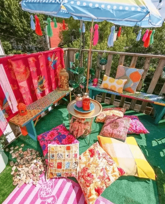 a colorful boho terrace with bright benches and pillows, bold blankets and an umbrella with colorful tassels