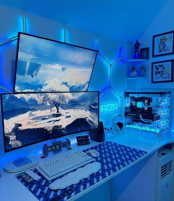 a cool blue gaming desk setup with two monitors, a keyboard, a PC, a corner shelf with decor and some artwork on the wall