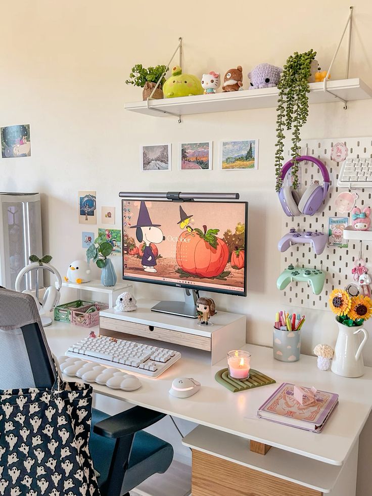 A fall themed gaming desk setup with a chair, a board with devices, shelves with pretty decor and potted plants