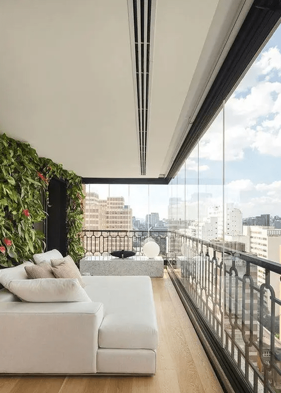 a large modern balcony with a living wall, a creamy sofa with pillows, a stone side table with quirky lamps is a very elegant and chic space