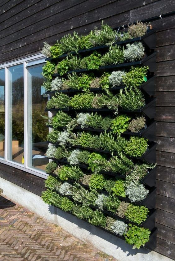 a large outdoor vertical garden that consists of multiple planters is a perfect idea for decorating a Scandinavian outdoor space