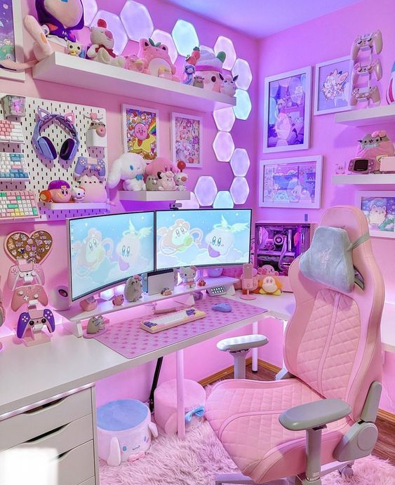 a lilac and pink gaming desk setup with a pink chair, a gallery wall, some lovely lights and plush toys and decor