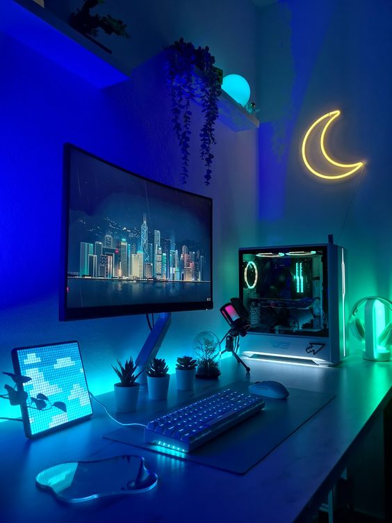 A lovely blue and green gaming corner with a moon lamp, a PC and some plants and built in lights is amazing