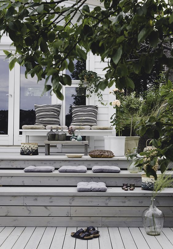 a lovely multi-level deck with lots of pillows, cushions and plants plus some decor is a smart solution