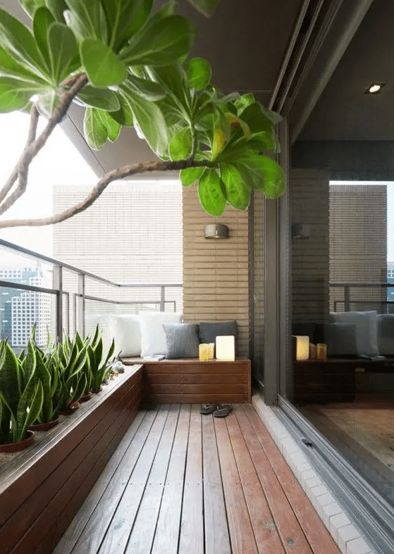 a modern and welcoming balcony with a rich-stained deck, a built-in bench and a flower bed with lots of succulents