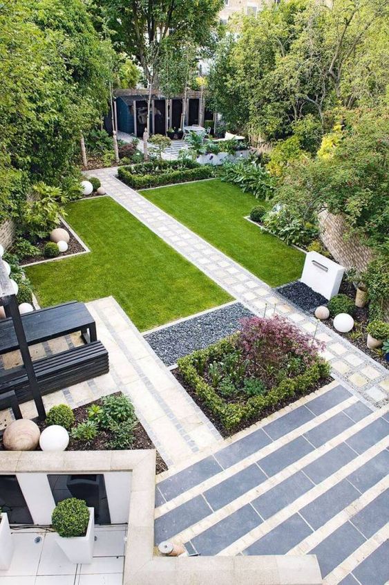 a modern garden with a green lawn, some garden beds with greenery and blooms, some decor and trees is amazing