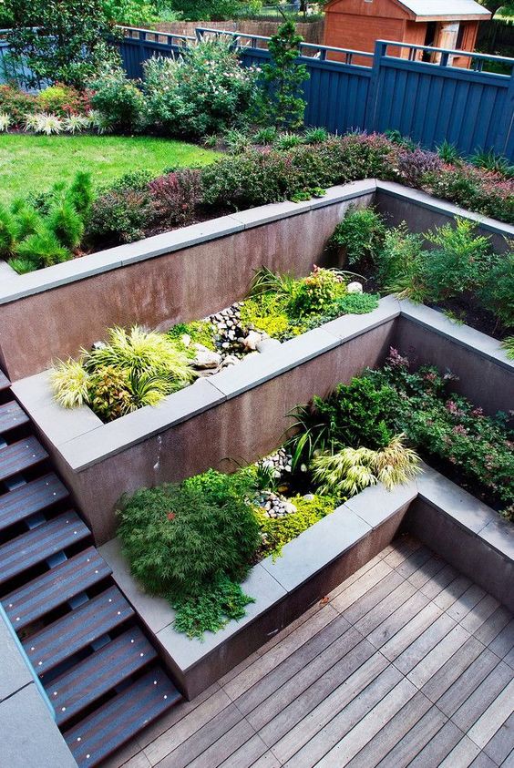 a multi-level garden with a deck, some potted plants and a green lawn on top is a gorgeous idea if you don't have much space