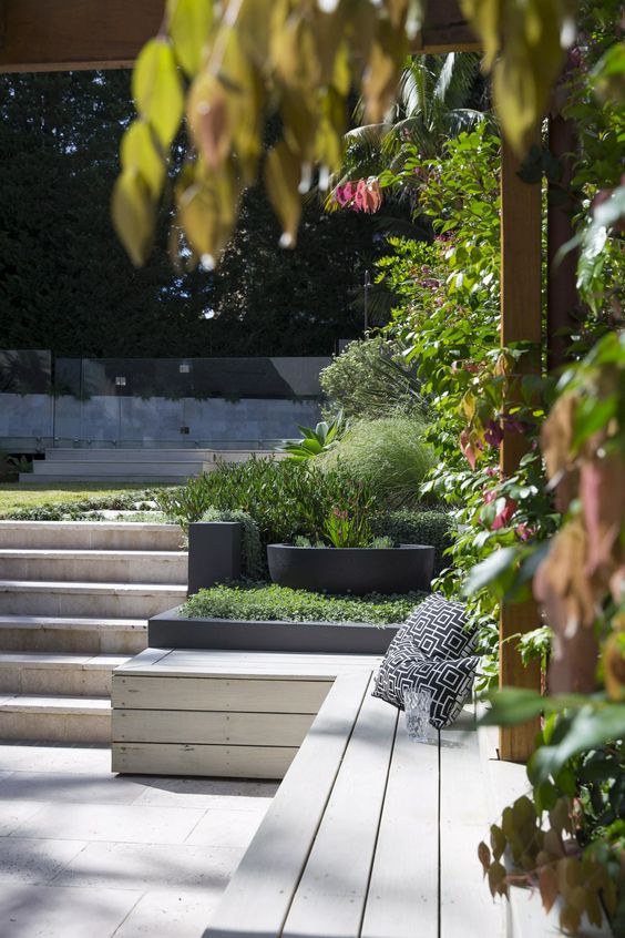 a multi-level garden with a green lawn, plants and trees and a deck is a cool idea for a modern or contemporary space