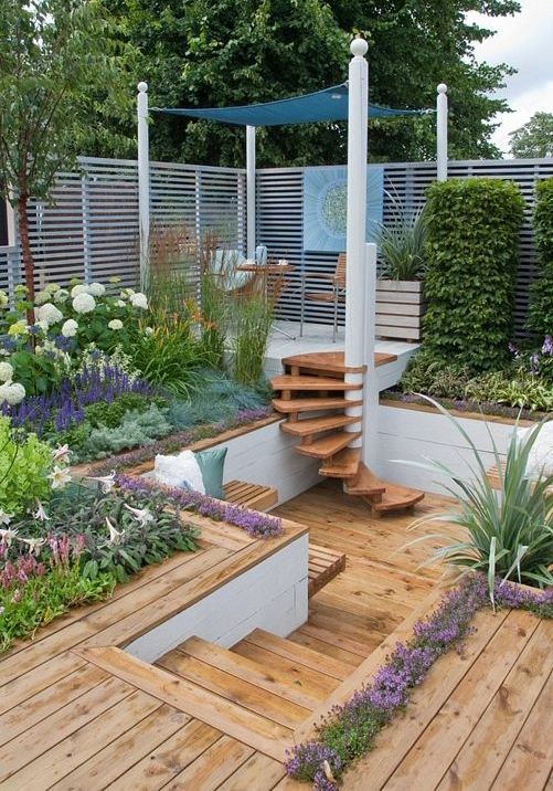 a multi-level garden with decks, benches, some furniture and lots of blooms and greenery is cool