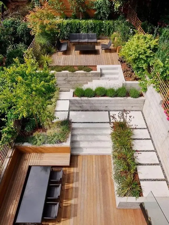 a multi-level outdoor space with a dining zone, greenery and trees, an outdoor living room