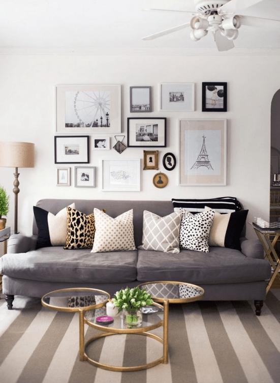 a neutral living room with a taupe sofa, a pretty contrasting gallery wall and a grey and tan strip rug to make the space cooler