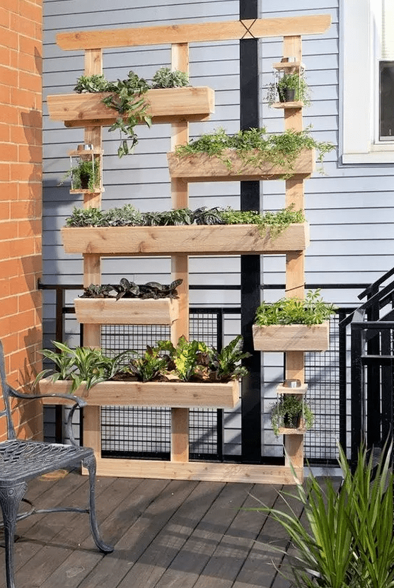 a non-stained wood vertical garden with multiple planters is a lovely idea for any outdoor space, a balcony, a terrace and many others